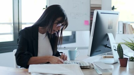 Video of attractive young designer woman working in a design project while choosing materials in the office.
