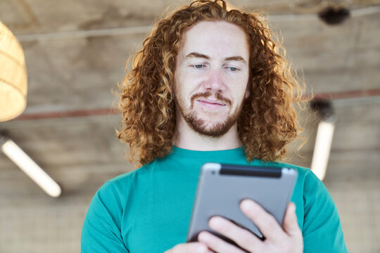 Handsome man surfing through internet on digital tablet at home