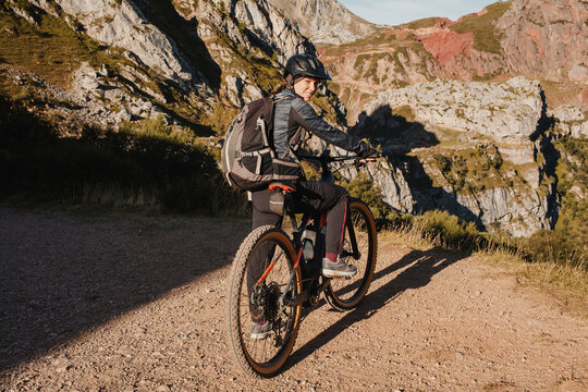 Smiling woman on electric mountain bike standing at Somiedo Natural park, Spain