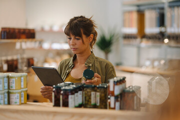 Female owner checking inventory on digital tablet in coffee shop