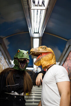 Female with male friend wearing dinosaur mask while traveling in train