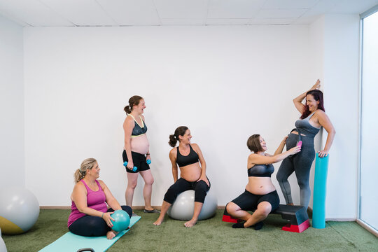 Group Of Pregnant Woman Doing Exercise At Yoga Studio