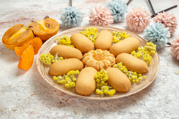 a plate of cookies and palms and pale blue and pink flowers on white background