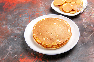 Classic American homemade pancakes on a white plates on mixed color table