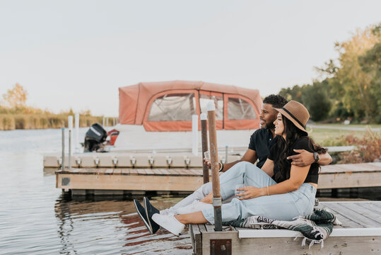 Boyfriend and girlfriend admiring view while sitting on pier