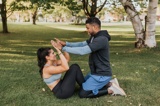 Man and woman giving high five while exercising at backyard