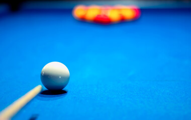 Pool cue and ball ready to break on the billiard table