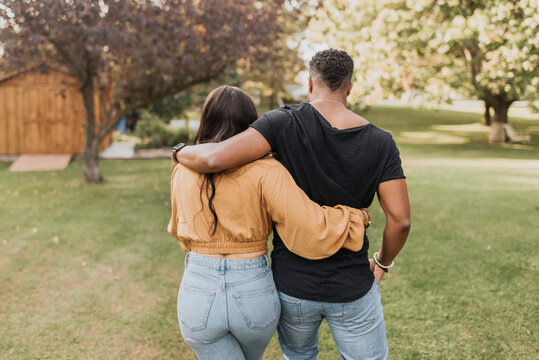 Mid adult man and woman with arm around walking at backyard