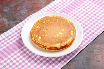 Delicious pancakes on a pink stripped towel on mixed color background