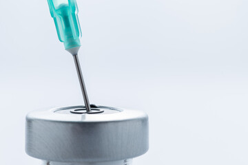 A hypodermic needle inside of a vial containing a vaccine