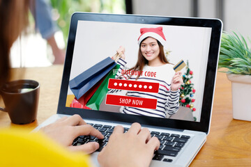 Woman entering Christmas discount coupon code on laptop screen to get the shopping online promotion, online shopping ,digital marketing business and technology
