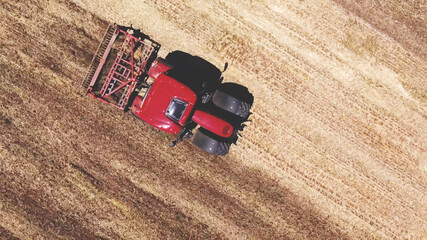 top aerial view of agriculture red tractor plowing the field, land plow.
