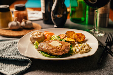 Served plate of seared tenderloin steak with side of baked baby potatoes and garlic dip.Filet mignon dinner for special occasion and home celebration.Homemade special occasion main course
