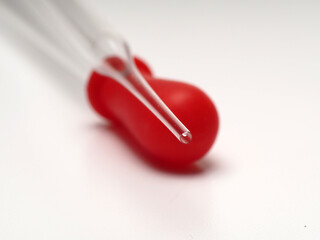close up shoot of glass pipette with red rubber on a white isolated background