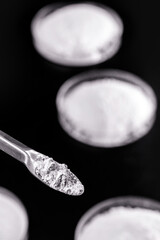 spatula with small portion of calcium carbonate, isolated black background