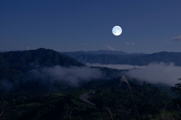 Beautiful white full moon over the mountains in the winter