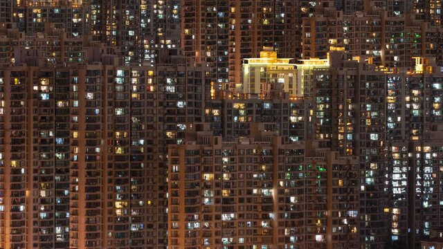 Day to night transition timelapse of many Shanghai residential buildings. Chinese crowded city apartments with lights at midnight. Fast paced modern Asian night-scape time lapse in urban metropolis.