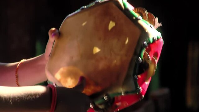 Young Woman Hands playing a Tambourine at Home. Close Up.