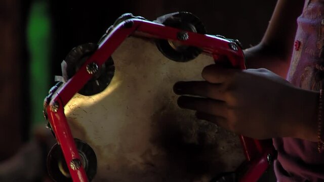 Young Woman Hands playing a Tambourine at Home. Close Up.