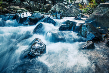 Mountain stream with strong current and rocks 