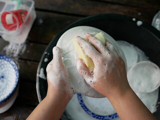 Fototapeta premium hand washing dish with sponge and dish washing liquid.