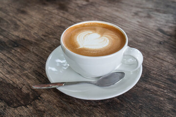 latte art on hot coffee in white ceramic cup in cafe