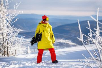 Woman snowboarder poses with board.