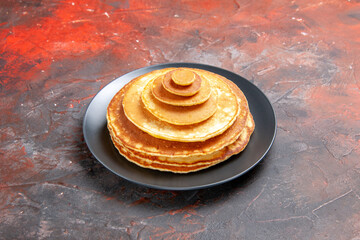 Fototapeta na wymiar Close up view of simple homemade pancakes in a black plate