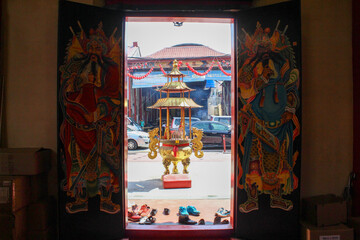 A picture taken at one of the temple located in the heart of kuching city, taken from the inside of the temple, facing the outside to showcase a beautiful art drawn on the doors.