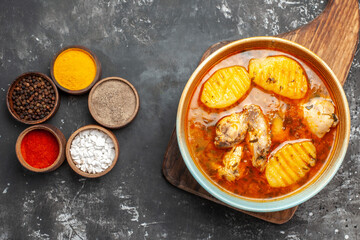 Mixed spices and bony chicken meal on wooden chopper board