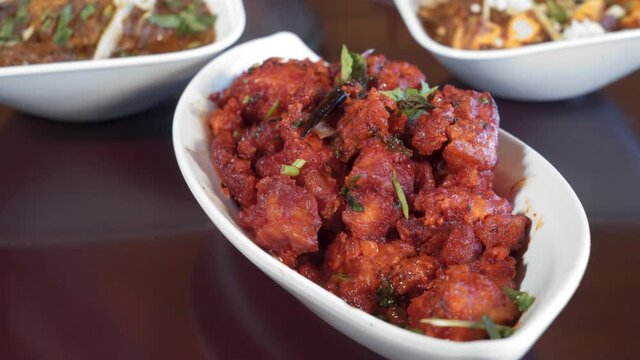 Fork picks up gobi manchurian, a bite of fried cauliflower in spices, slider close up 4K