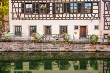 Fototapeta na wymiar Old town water canal of Strasbourg, Alsace, France. Traditional half timbered houses of Petite France