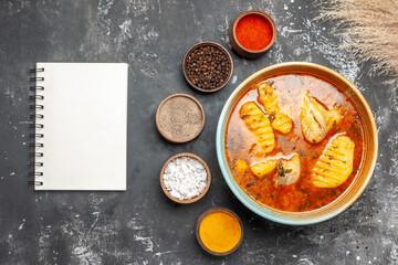 Homemade chicken dish spices set and notebook on dark background