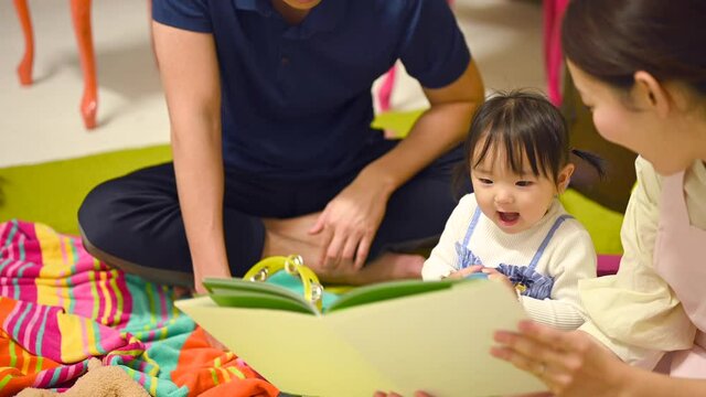 赤ちゃんに絵本の読み聞かせをする保育士