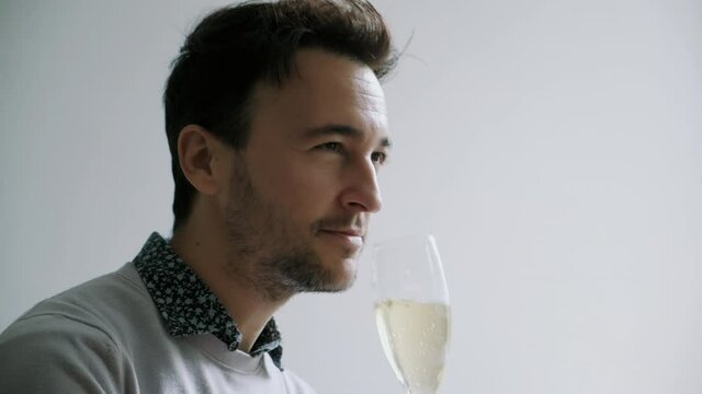 A man raising a glass of wine and taking a drink