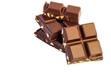 Broken pieces of milk chocolate with nut crumbs on an isolated white background.