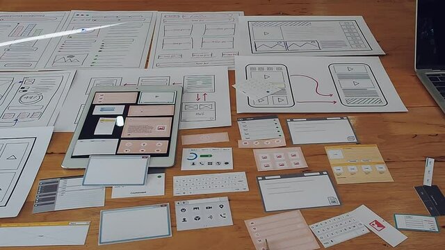 Top view and panning left of Creative flat lay UX designer working space and office supplies. Smartphone and tablet application layout prototype project.