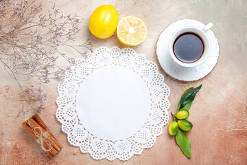 Fototapeta na wymiar Horizontal view of a cup of tea black tea lemon napkin and tea on colourful background