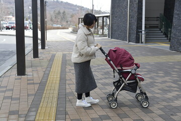 バス停でバスを待つ妊婦の女性