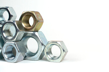 many metal nuts stacked on a white background