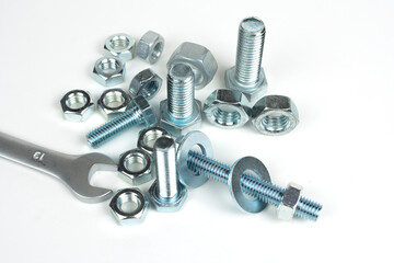 bolts and nuts on a rough plan with a wrench