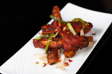 Salt and chili pork spare ribs with peppers, onions and garlic