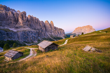 Scenic sunrise view of abandoned old wooden house at Passo di val Gardena valley at sunrise . Dolomites Alps. Italy