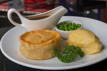 British pie served with potato mach, peas and gravy. Pub food