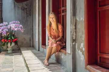 Naklejka premium Woman tourist on background of Temple Ngoc Son in Hanoi, Vietnam.Temple of Literature is also called temple of Confucius. Vietnam reopens after coronavirus quarantine COVID 19