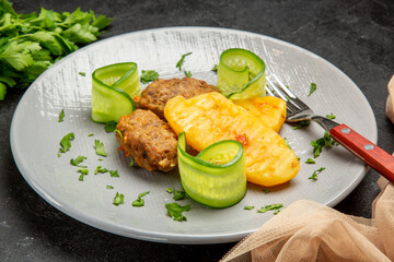Side view of well-cooked cutlet in a white plate on black table