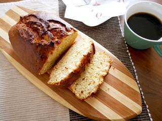 カッティンボードに置かれたパウンドケーキとコーヒー