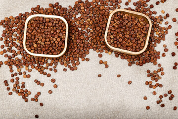 Raw gray peas in wooden bowls on sack cloth with vignette. Legumes bean seed. Organic healthy diet food. View from above.