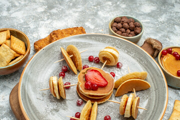 Close up view of delicious pancakes biscuits and cakes for breakfast on cutting board on blue background