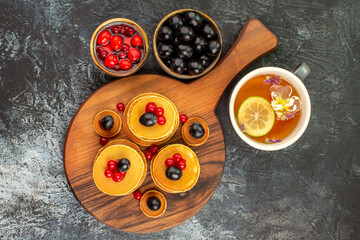 Breakfast time with simple buttermilk pancakes fruits and a cup of tea